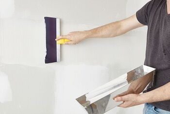A painter doing drywall finishing